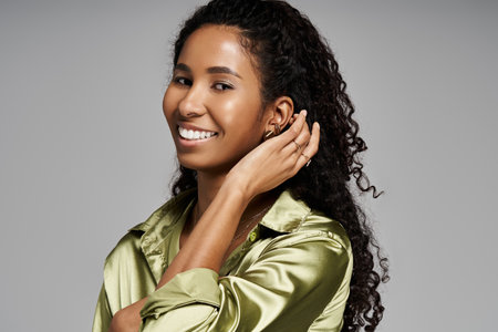 Beautiful african american woman showcasing exquisite jewelry and her unique style.の写真素材