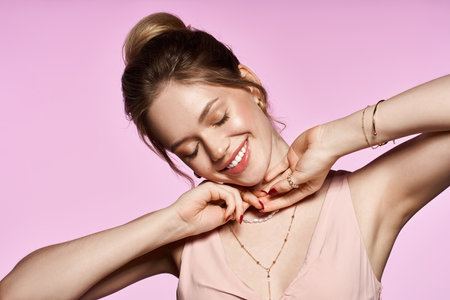 A young woman smiles joyfully while presenting her trendy spring attire and elegant jewelry.の写真素材