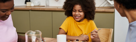 A happy young daughter enjoys breakfast with her loving parents, making memories together.の写真素材
