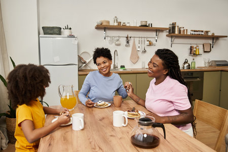 A young family enjoys a cheerful breakfast together, sharing smiles and tasty pancakes.の写真素材