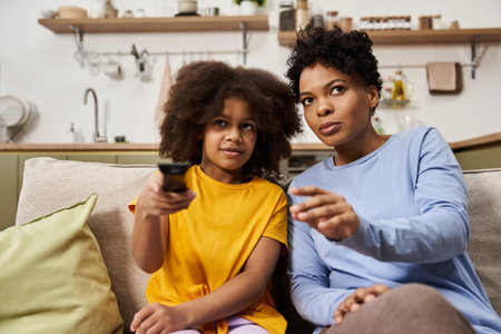 A young family shares a joyful experience while watching their favorite show at home.の写真素材