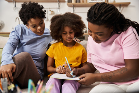 Two mothers and their daughter share an artistic and joyful bonding experience together.の写真素材
