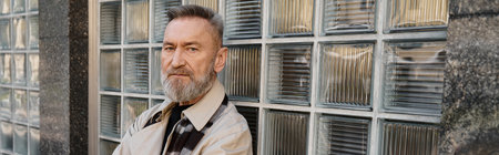 Stylish senior man confidently strolling through a vibrant urban landscape, showcasing his chic fashion sense and charisma in the cityの写真素材