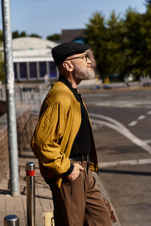 Stylish senior man enjoying a sunny day while strolling through the urban landscape with a confident demeanorの写真素材