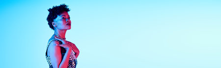 A stunning African American woman elegantly displays her fashion sense in a captivating moment.の写真素材