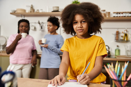In a warm kitchen, a young girl draws while her family watches on with smiles and encouragement.の写真素材