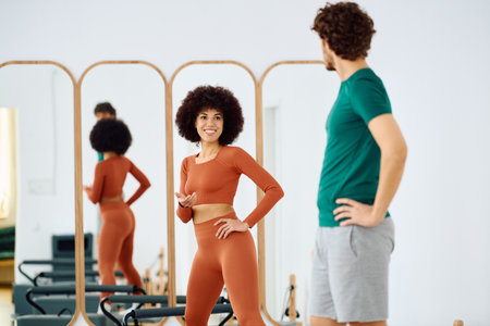 Two participants enjoy a lively pilates session filled with energy and connection.の写真素材