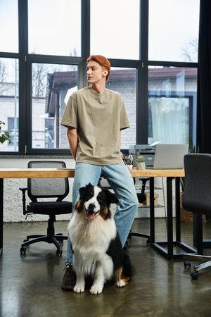 Dedicated young professional enjoys a moment with his dog in a bright office setting.のeditorial素材