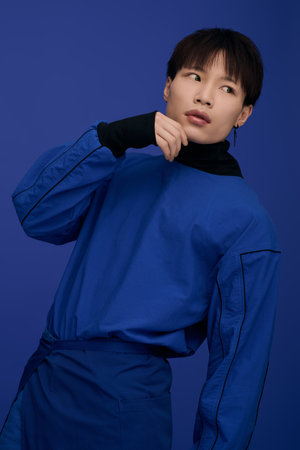 A charming young Asian man radiates confidence with his expressive face and stylish outfit.のeditorial素材