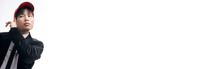 Attractive young asian man poses confidently in modern attire, radiating style and charisma.の写真素材