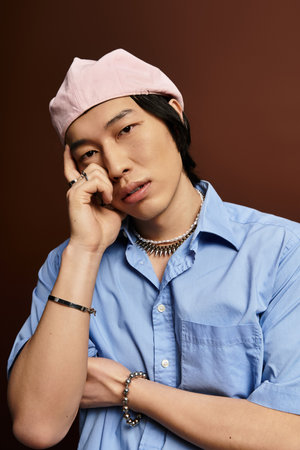 A handsome young man in a pink cap exudes confidence, showcasing stylish fashion choices.の写真素材