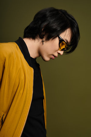 A fashionable young man poses confidently in a modern studio, exuding style and charm.の写真素材