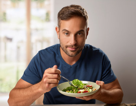 A man enjoys a colorful salad, embodying relaxation and self love in an urban setting.の素材