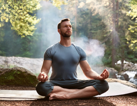 A man engages in mindful meditation amid lush greenery, finding peace and reflection in nature.の素材