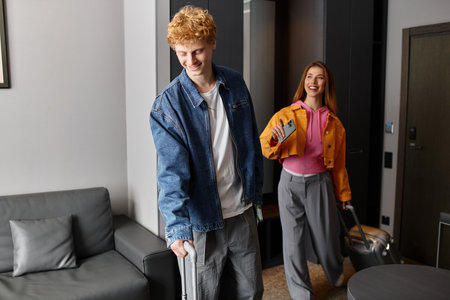 Excited young couple enjoys their time in a charming hotel, embracing love and adventure together.の写真素材