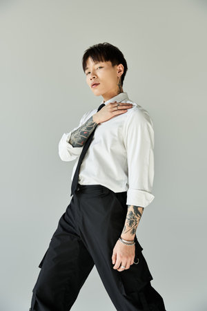 Stylish man in sharp attire poses confidently against a minimalist backdrop.の写真素材