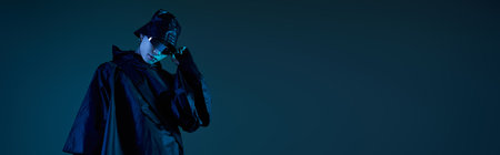 A stylish Asian man relaxes in a dim setting, exuding cool confidence.の写真素材