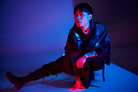 Handsome man showcases his unique style with a confident pose in an artistic setting.の写真素材