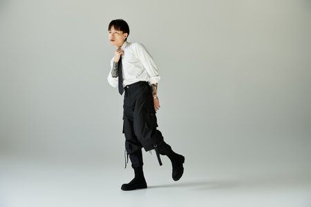 Confident young man poses in a tailored outfit, showcasing modern style and attitude.の写真素材