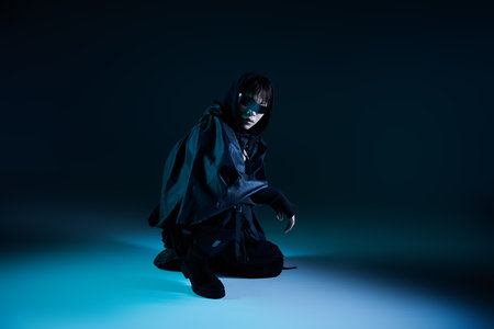 Confident young man in dark attire blends modern fashion with unique artistic flair.の写真素材