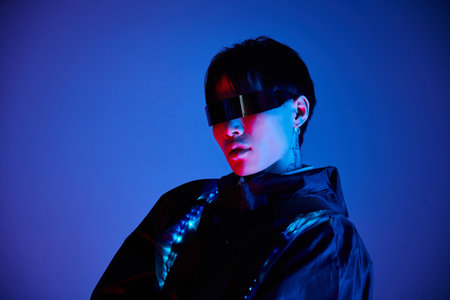 A stylish young Asian man poses under vibrant blue and purple lights.の写真素材