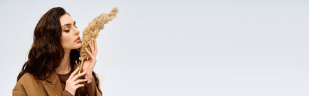 A young woman with lovely long brown hair enjoys springtime in her cozy coat, bannerの写真素材