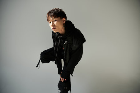 A stylish young Asian man showcases a trendy outfit in a chic setting.