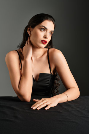 A striking young woman with brown hair and red lips poses elegantly.のeditorial素材