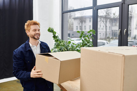 A cheerful man organizes his belongings for a move in a brightly lit space.の写真素材