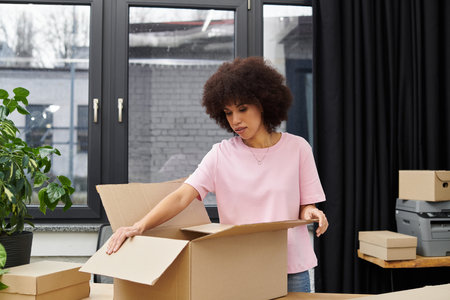 A woman carefully unpacks boxes in a bright and contemporary room, surrounded by greenery.
