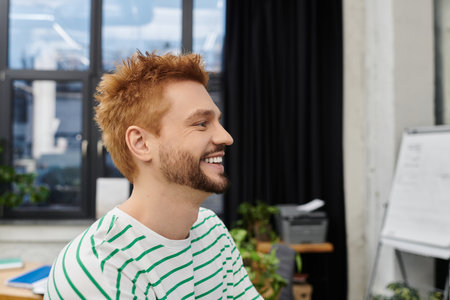 A cheerful man in a striped shirt enjoys packing and unpacking while preparing for a move.の写真素材