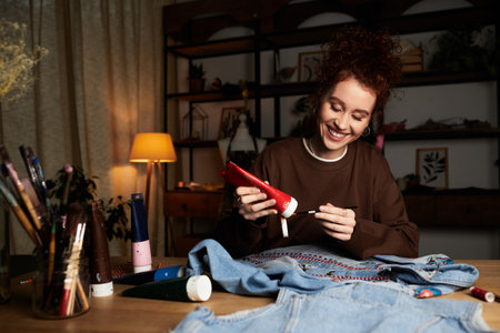 A young beautiful woman is crafting unique designs on denim in her inviting home workspace.