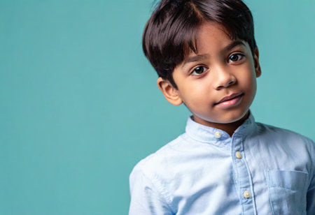 A captivating portrait of a young boy showcasing his joyful expression and stylish attire.の素材