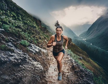 An athlete races up a muddy hillside, embracing the challenge of nature's beauty and intensity.の素材