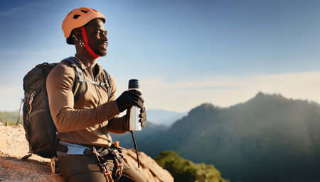 African american hiker takes a moment to relax and appreciate the magnificent landscape after an ascent.の素材
