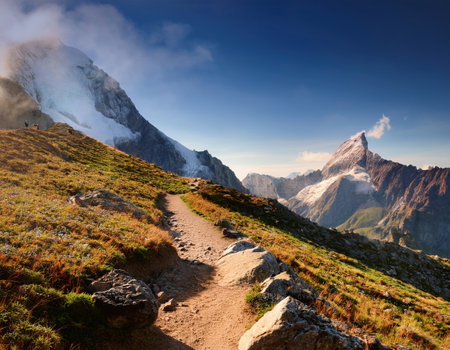 Majestic peaks create a stunning backdrop as thrill-seekers navigate winding paths at dawn.の素材