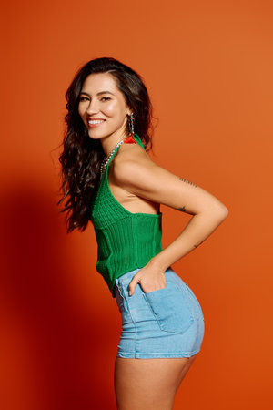 A young woman in trendy summer clothes smiles brightly on a sunny day.のeditorial素材