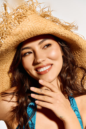 A beautiful young woman showcases summer vibes while wearing a stylish straw hat and bright attireのeditorial素材