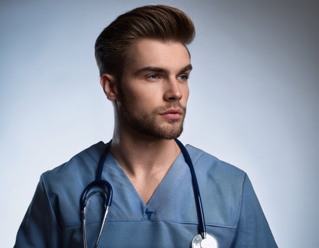 A healthcare worker in scrubs reflects on patient care in an emergency setting.の素材