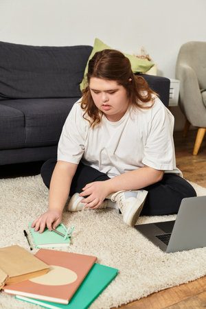 A young woman with Down syndrome focuses on her creative tasks while surrounded by comfort at home.