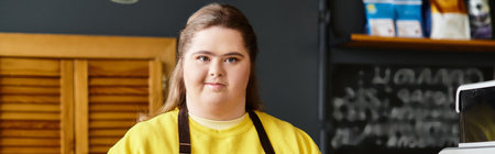 In a vibrant cafe, a young woman with Down syndrome confidently engages in her surroundings.のeditorial素材