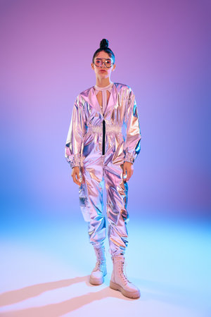 A young woman exudes confidence in a stylish, holographic outfit that embodies modern fashion.のeditorial素材
