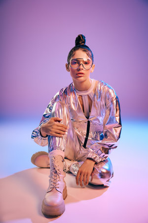 A graceful young woman models her stylish holographic outfit and trendy look.