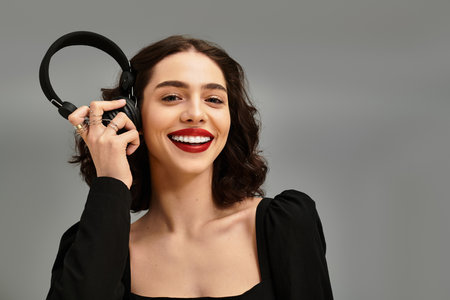 A confident young woman showcases her radiant red lips and braces, enjoying a moment of joy.のeditorial素材