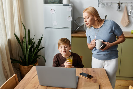 A mother bonds with her son over drinks at the kitchen table.
