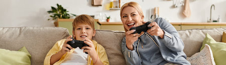 A mother and son are joyfully playing video games together on a comfortable couch, sharing smiles.