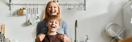 Bright kitchen fills with joy as mother embraces her son, both sharing laughter during meal prepの写真素材