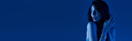 A young woman flaunts her stylish summer outfit in a vibrant evening setting.の写真素材