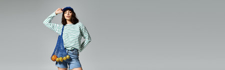 Confident young woman showcases fashionable summer outfit with playful accessories, exuding charm.の写真素材