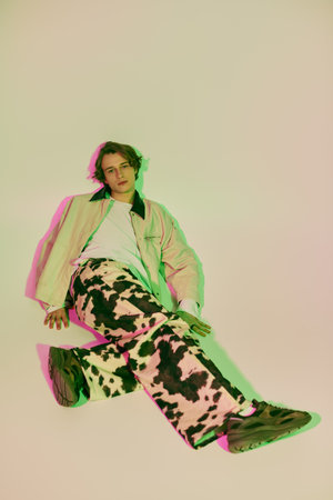 A stylish young man confidently poses in vibrant, contemporary fashion.のeditorial素材